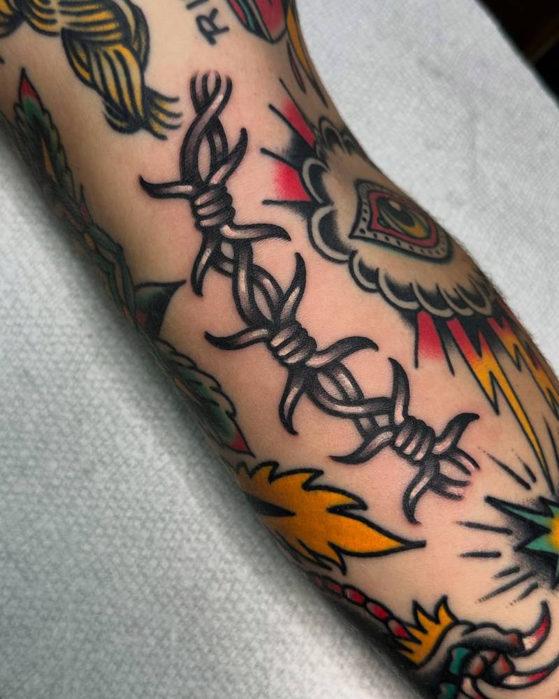Barbed wire gap filler tattoo located on the forearm.
