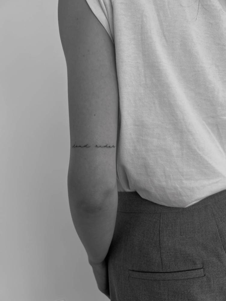 "Cloud rider" lettering tattoo handwritten on the tricep.