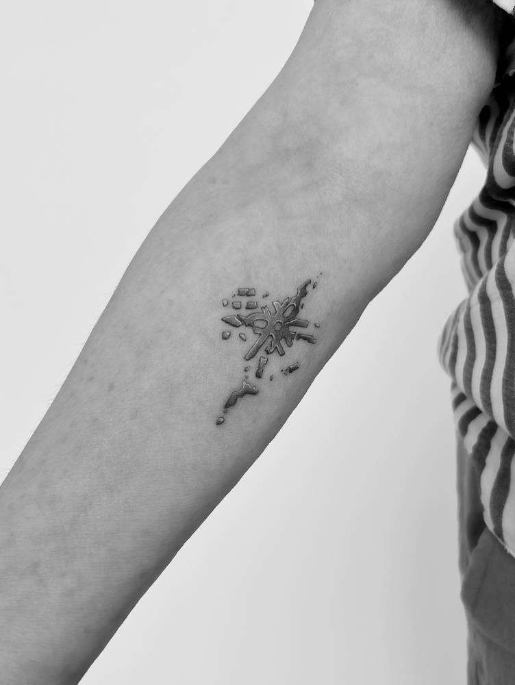 Broken snowflake tattoo located on the inner forearm, illustrative style.