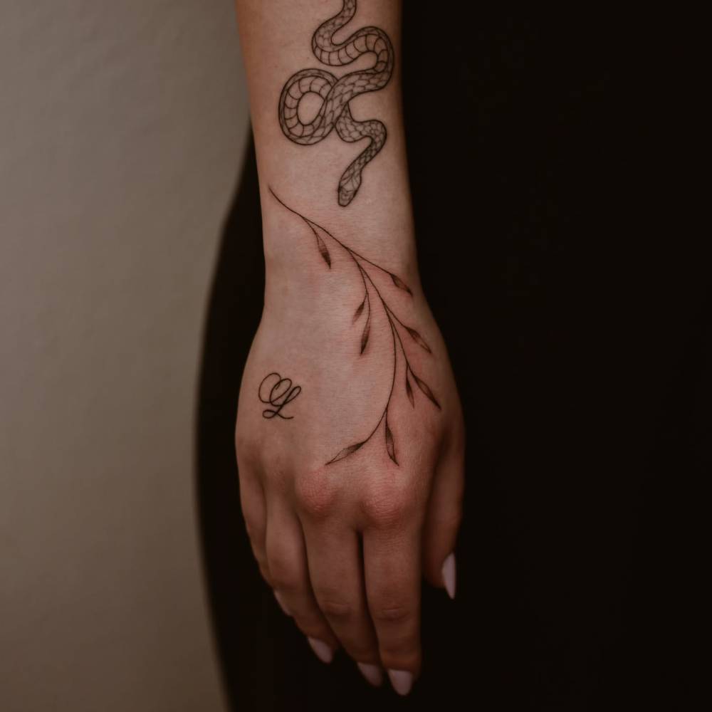 Sprig tattoo in illustrative style located on the hand.