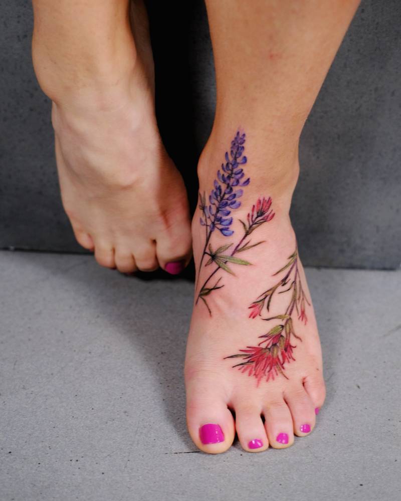 Indian paintbrush and lupine flower composition tattooed on the foot.