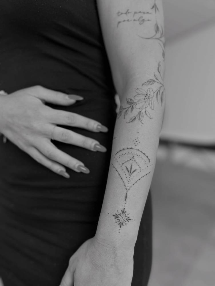 Ornamental tattoo in illustrative style located on the forearm.
