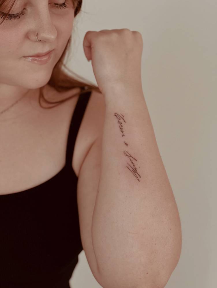 Names in handwritten font tattooed on the wrist.
