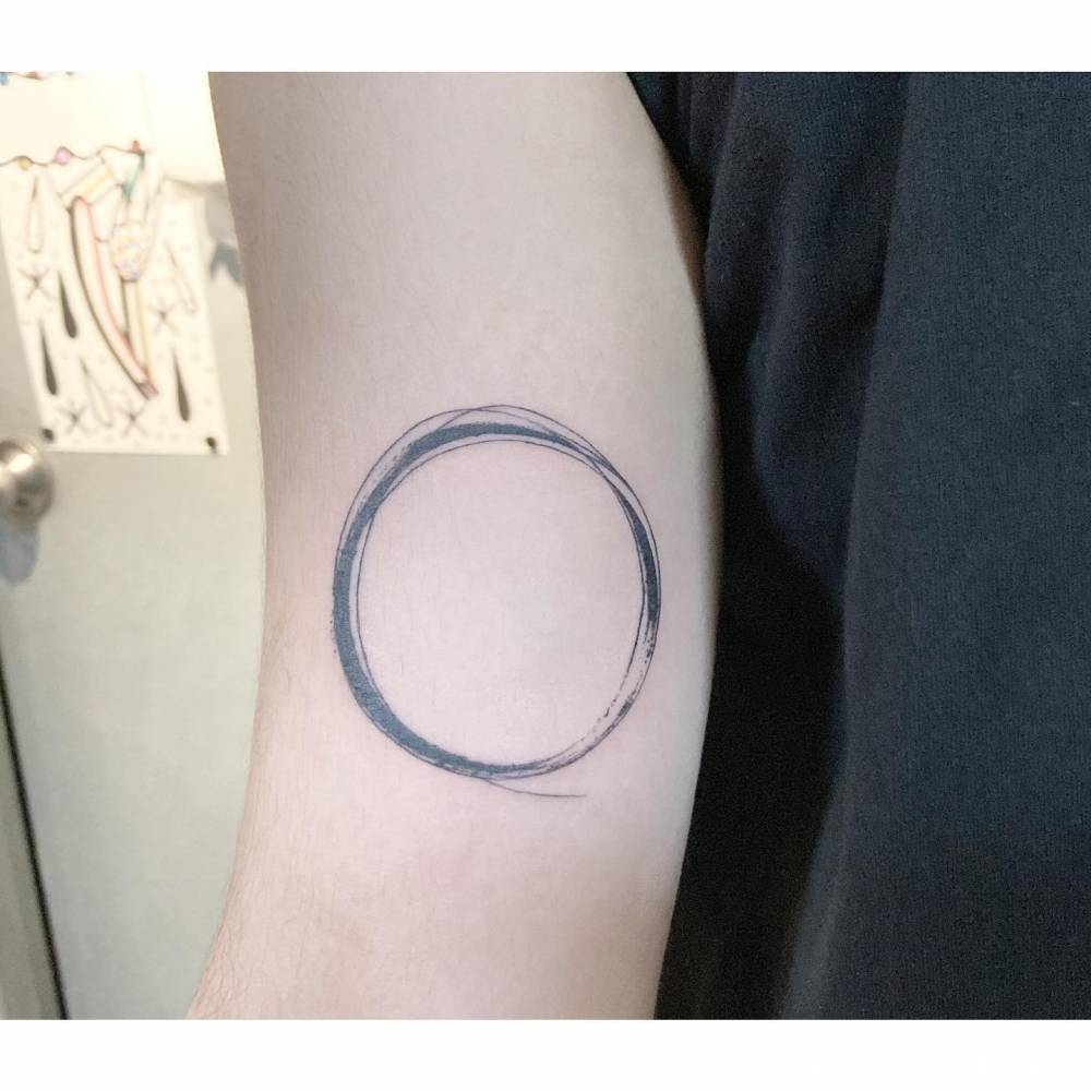 Sketch work style circle tattoo located on the inner arm.