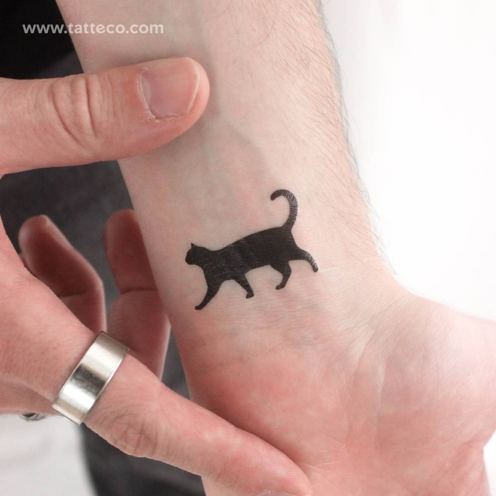 Little walking black cat temporary tattoo located on the wrist.