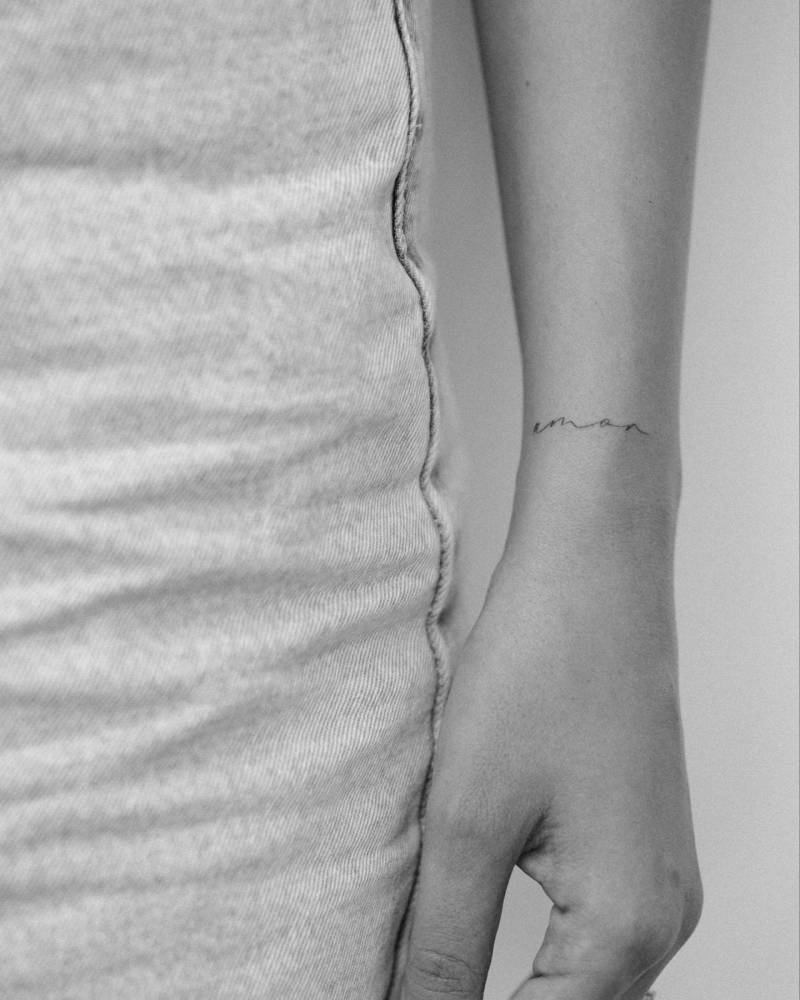 Little lettering tattoo of the word "amor" located on the wrist.
