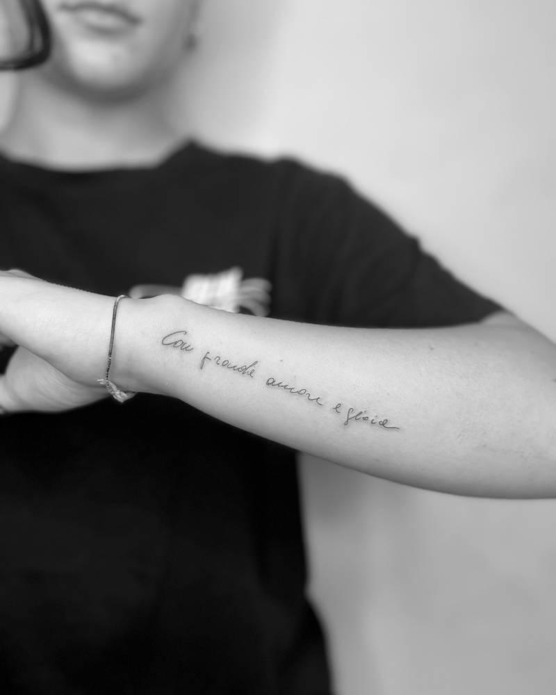 "Con grande amore e gioie" lettering tattoo in handwritten font.