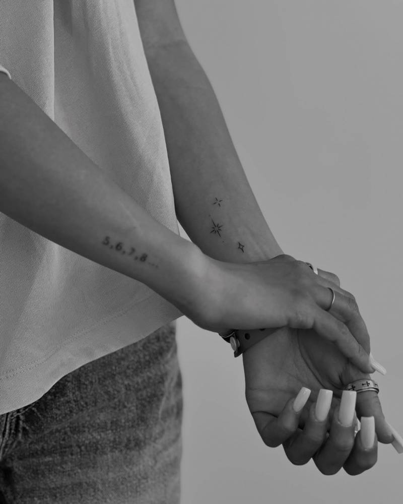 Sparkling stars tattoo in minimalistic style located on the wrist.