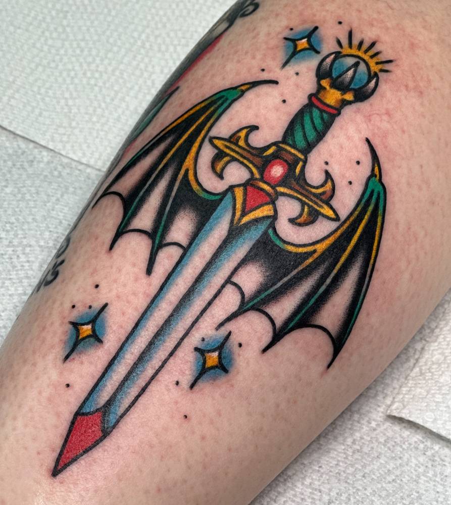 Traditional style dagger with wings tattoo located on the inner forearm.