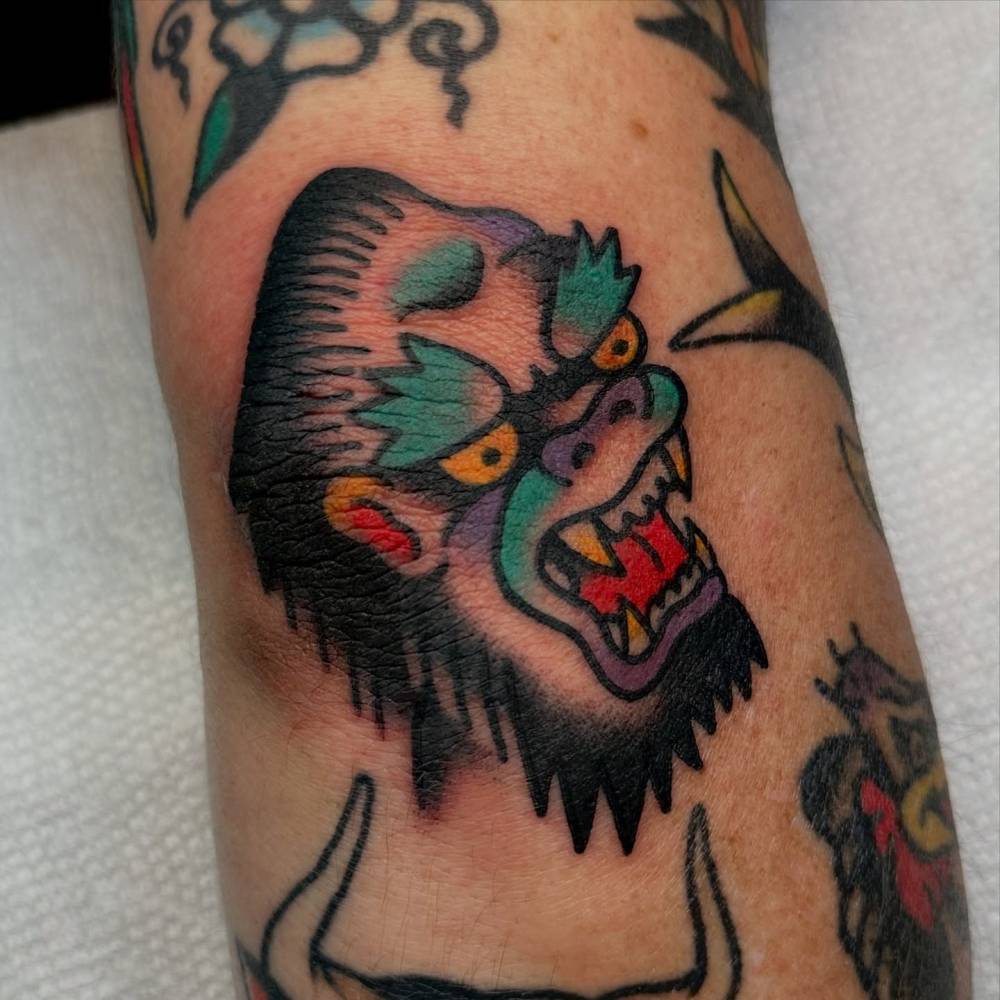 Gorilla portrait tattoo in traditional style done on the elbow.