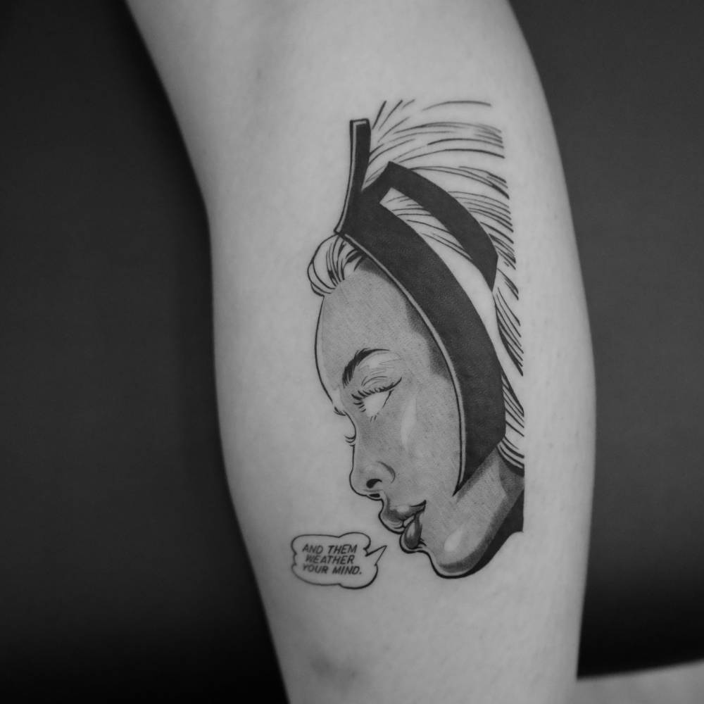 Storm portrait tattoo in comic style located on the calf.