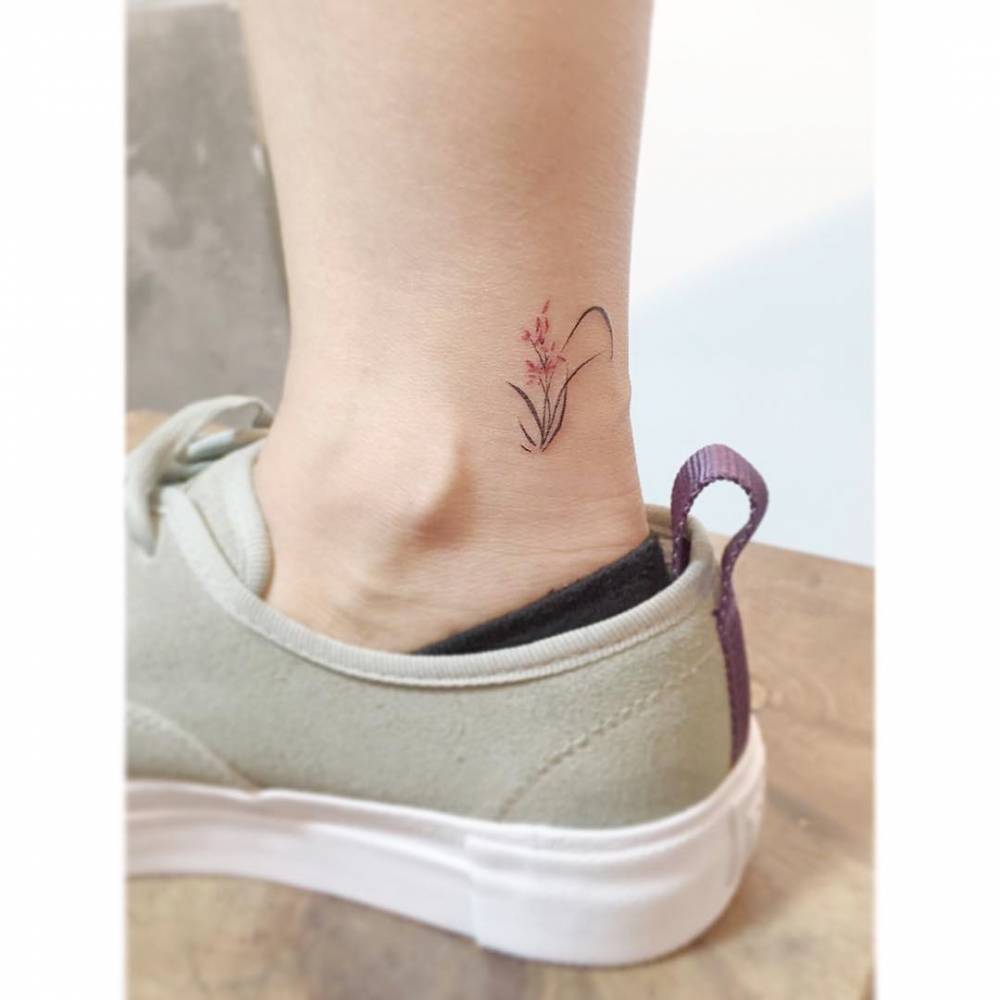 Watercolor style flowers tattooed on the ankle.
