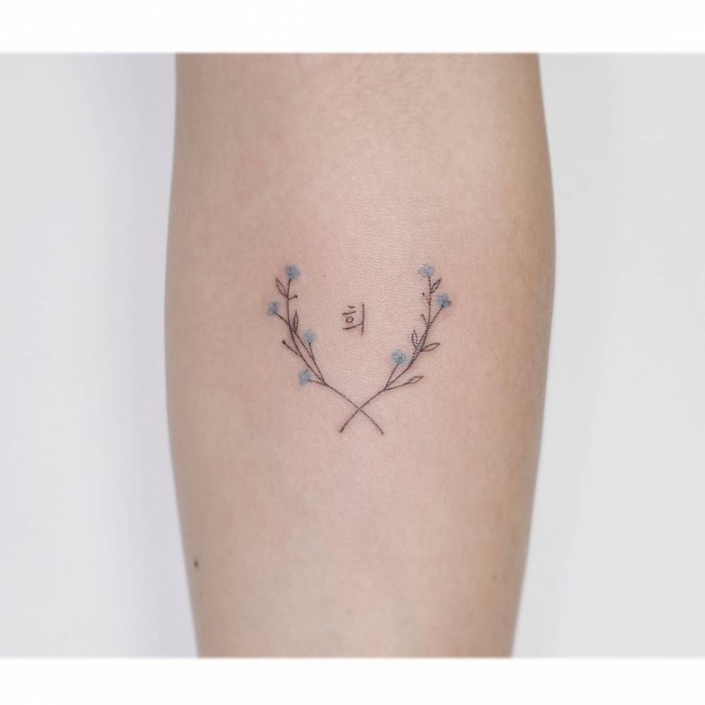 Fine line style laurel wreath tattoo located on the inner forearm.