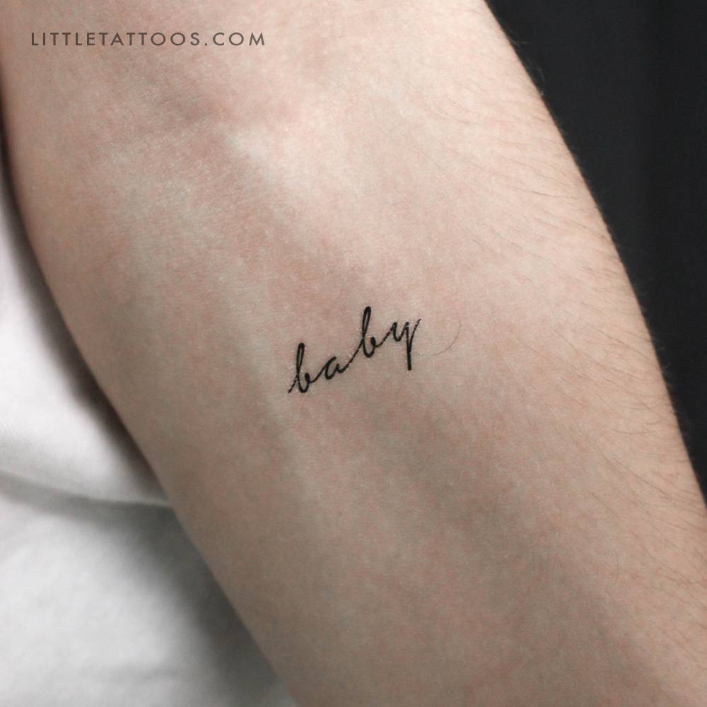 'Baby' temporary lettering tattoo located on the inner forearm.