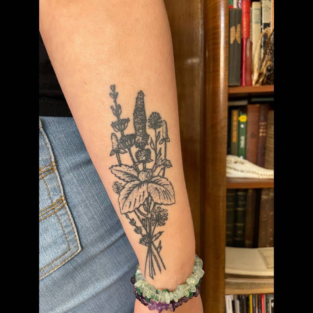 Healed blackwork style flower bouquet tattoo located on the wrist.