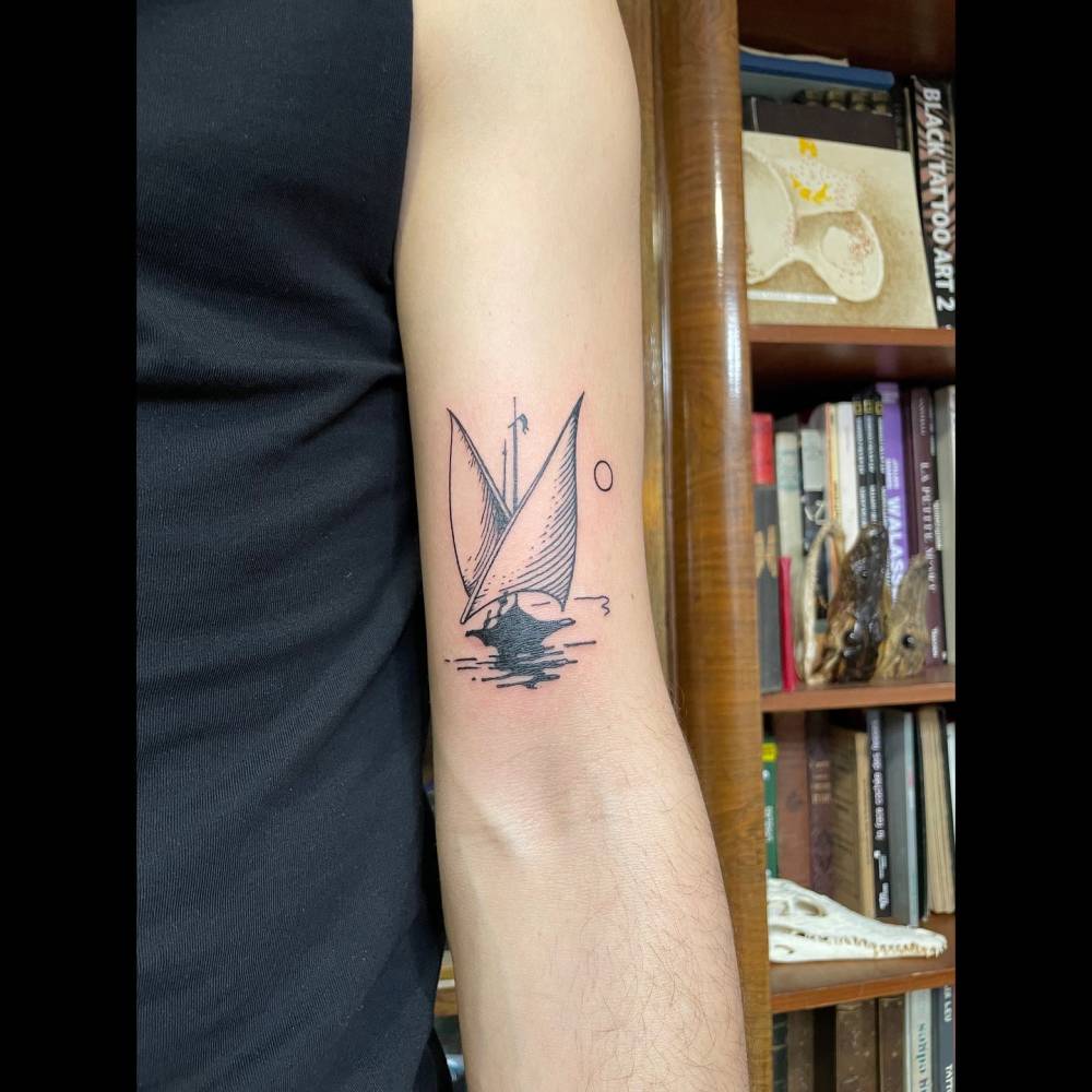 Blackwork style sailboat tattoo located on the bicep.