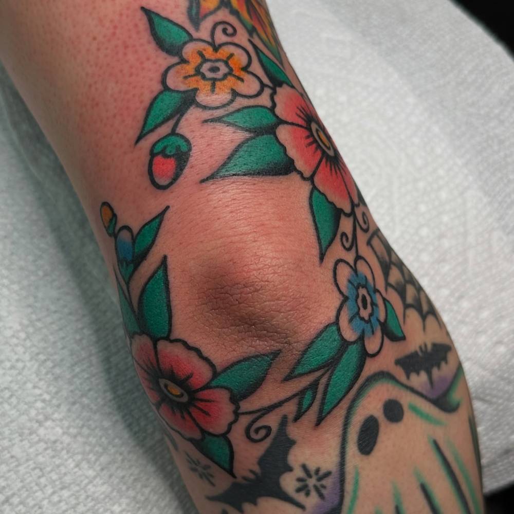 Traditional style flowers tattoo located on the elbow.