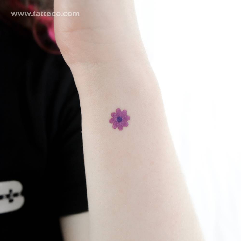 Minimalistic purple flower temporary tattoo located on the wrist.
