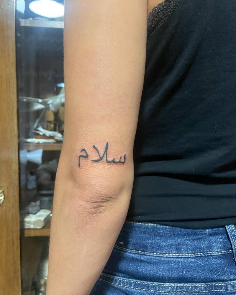 Arabic lettering tattoo located on the tricep.