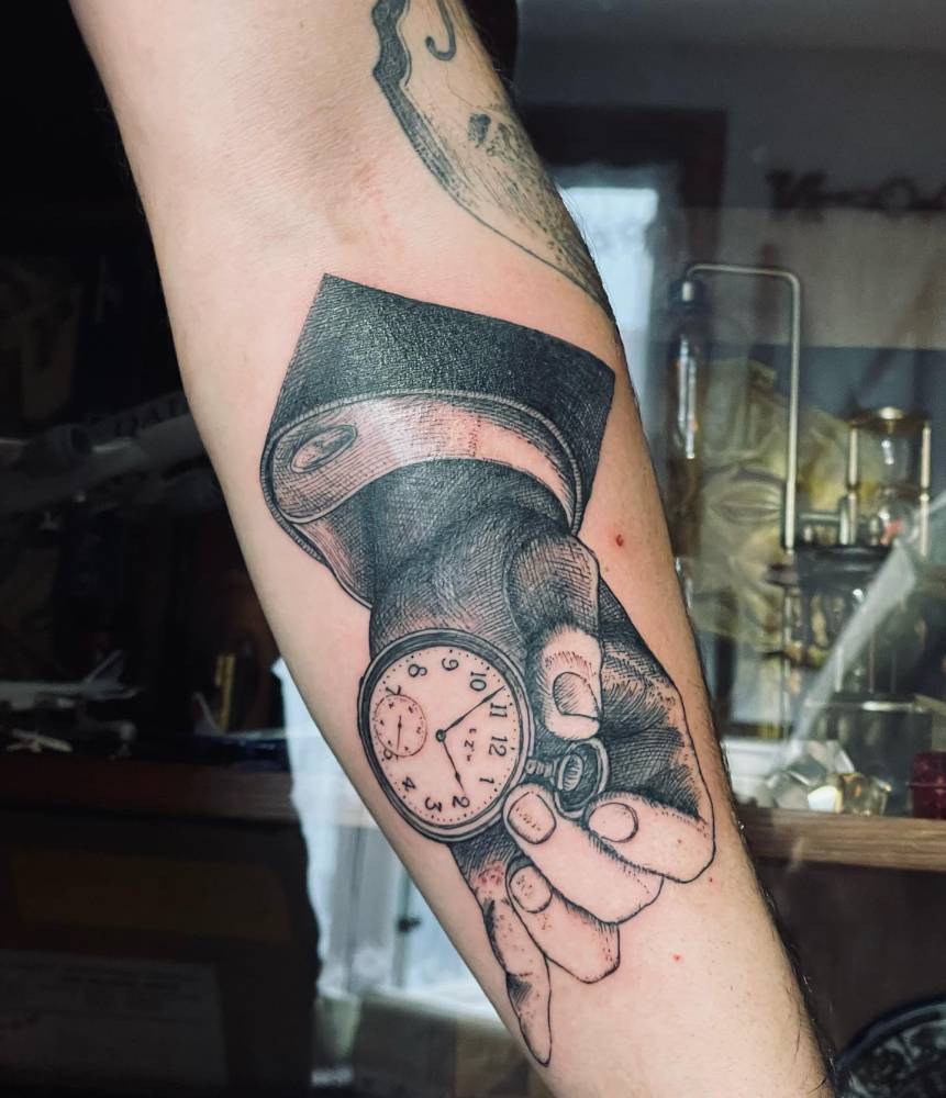 Graphic style pocket watch tattoo placed on the inner forearm.