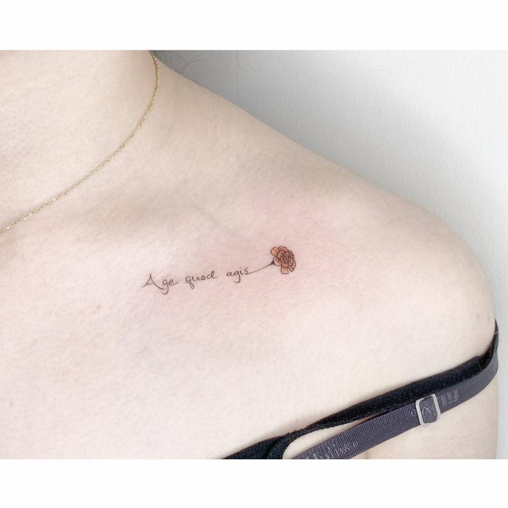 "Age quod agis" and carnation flower tattoo located on the collarbone.