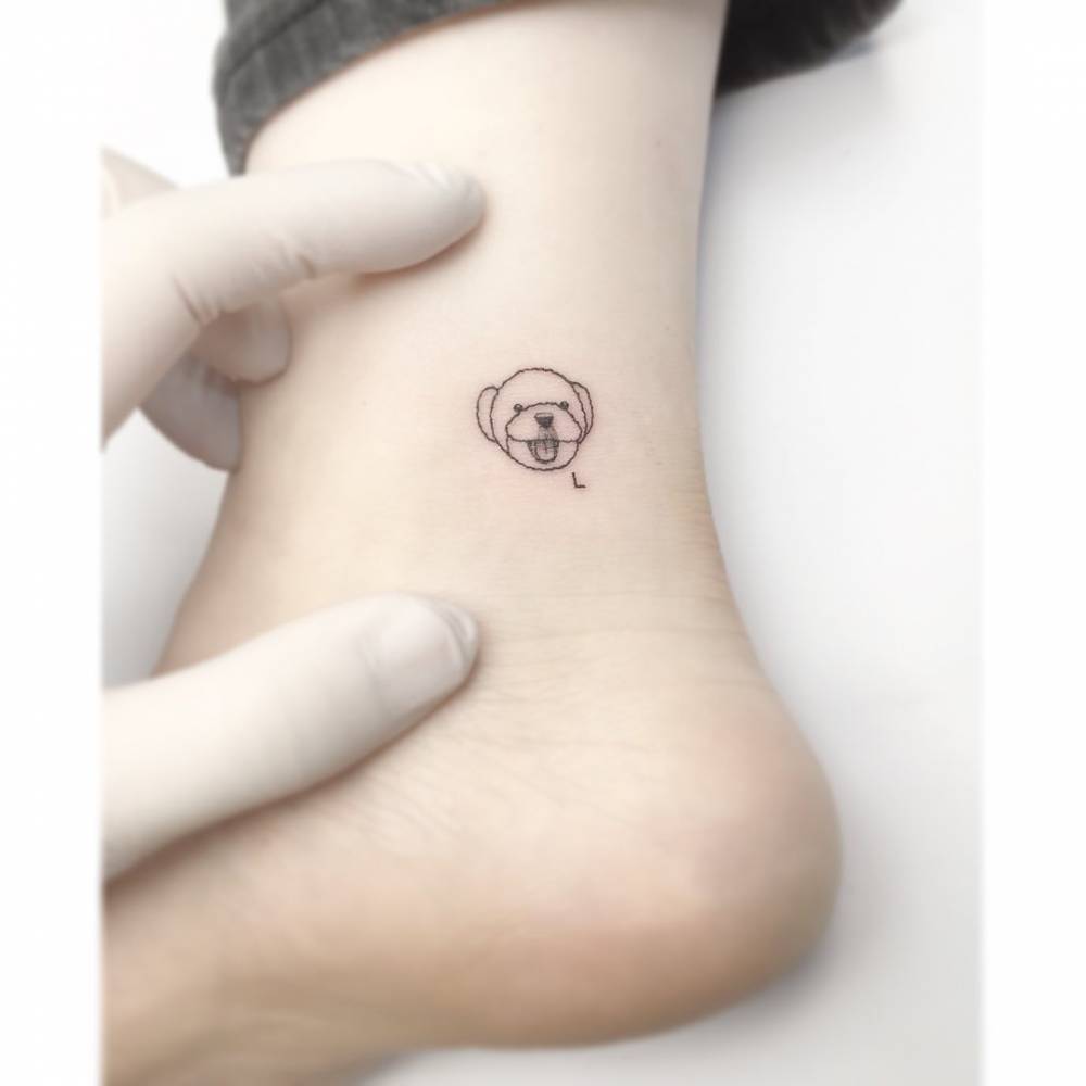 Minimalistic style Poodle portrait tattooed on the ankle.