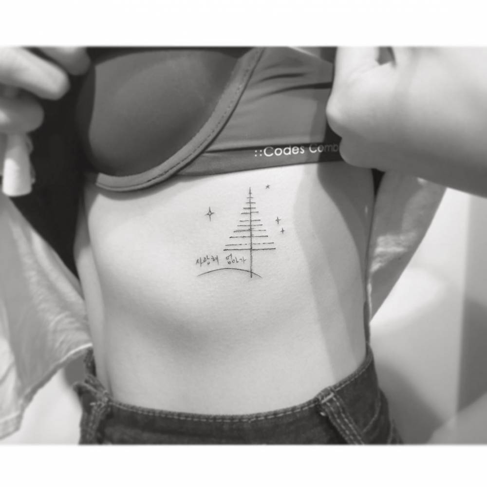 Pine tree and Korean lettering tattoo located on the rib.