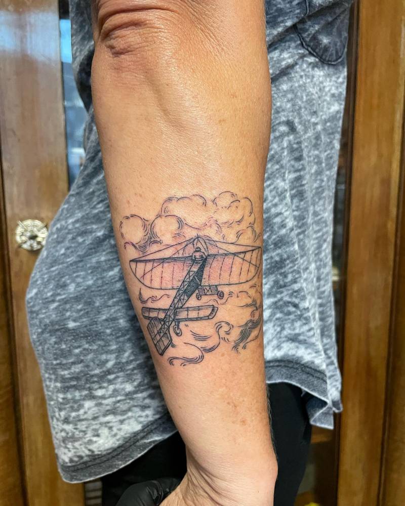 Plane tattoo in illustrative style located on the forearm.