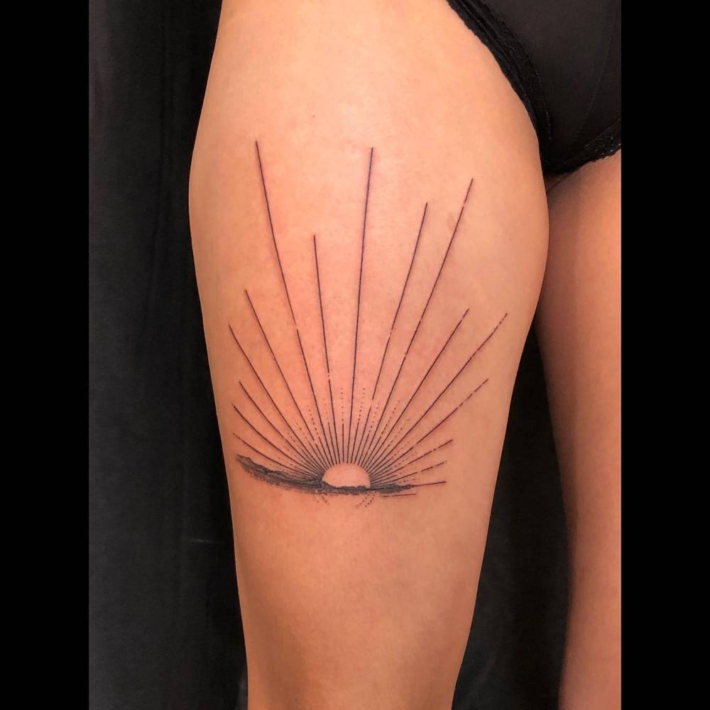Sunset tattoo in blackwork style placed on the thigh.