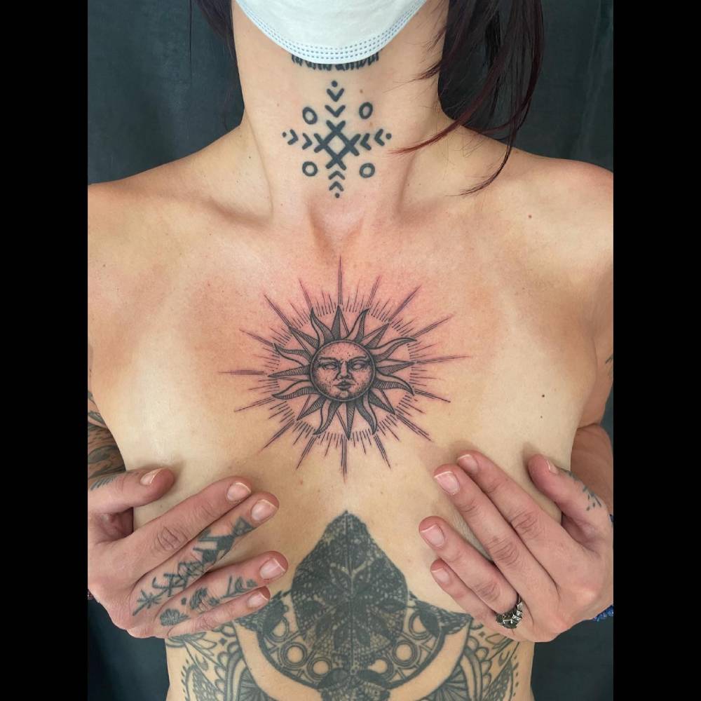 Blackwork style inti tattoo located on the chest.