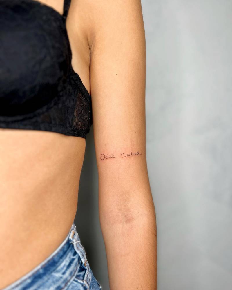 Handwritten lettering tattoo located on the bicep.