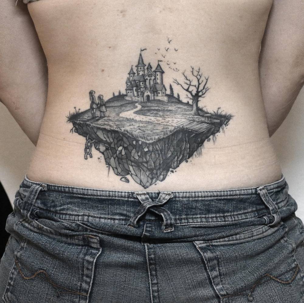 Healed floating castle tattoo located on the lower back.