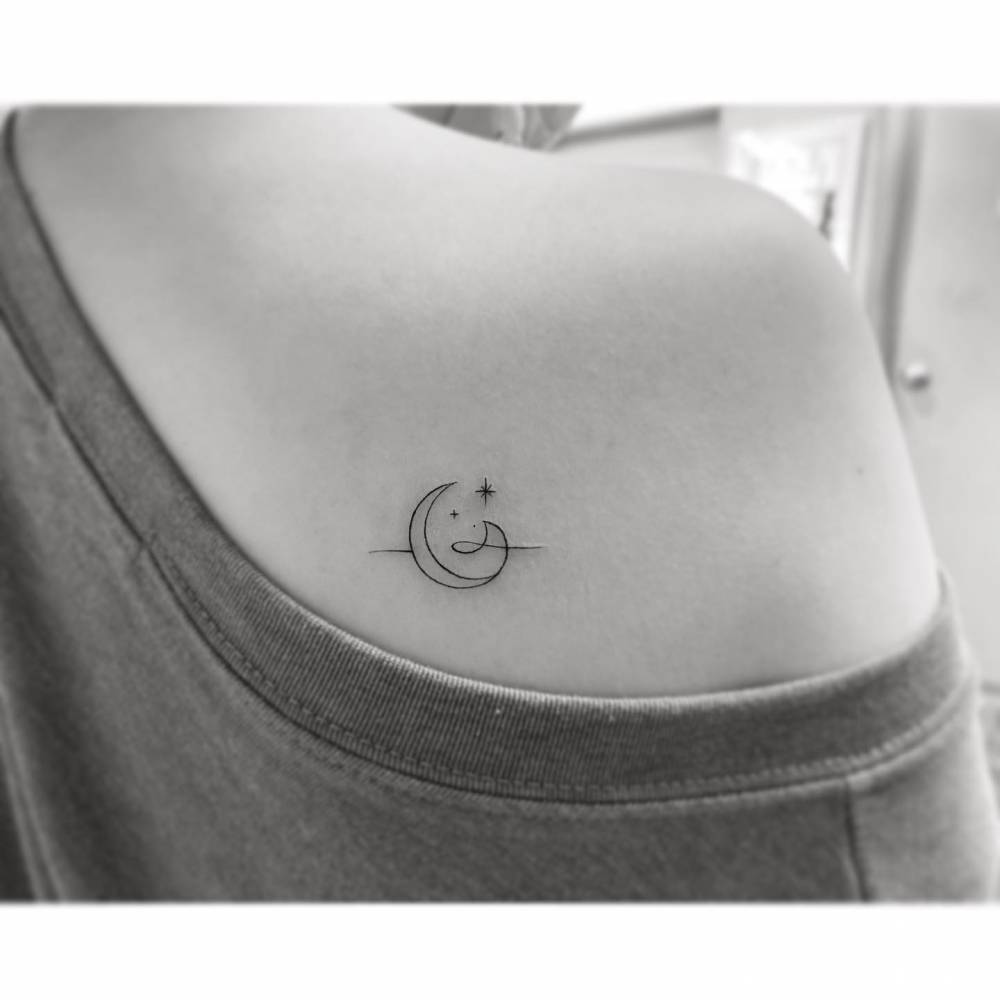 Minimalistic style wave, moon ans stars tattoo located on the shoulder blade.