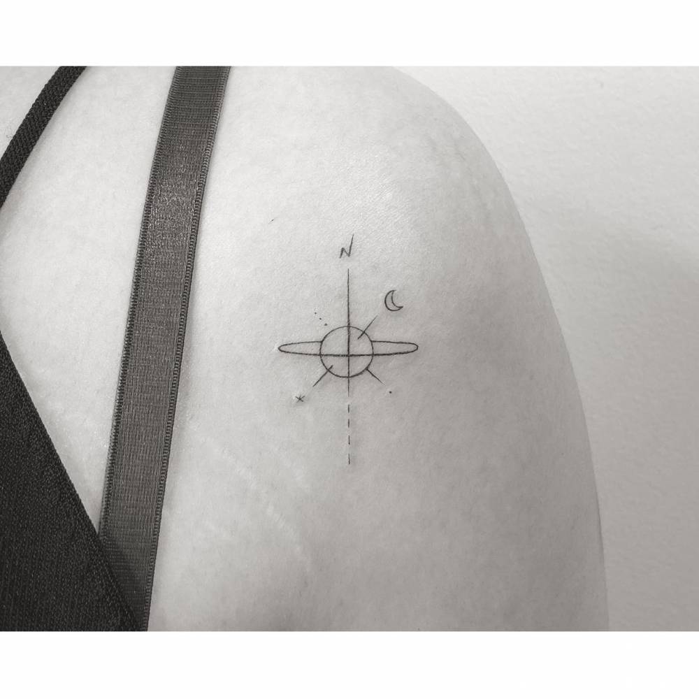 Compass rose tattoo in minimalistic style done on the shoulder.