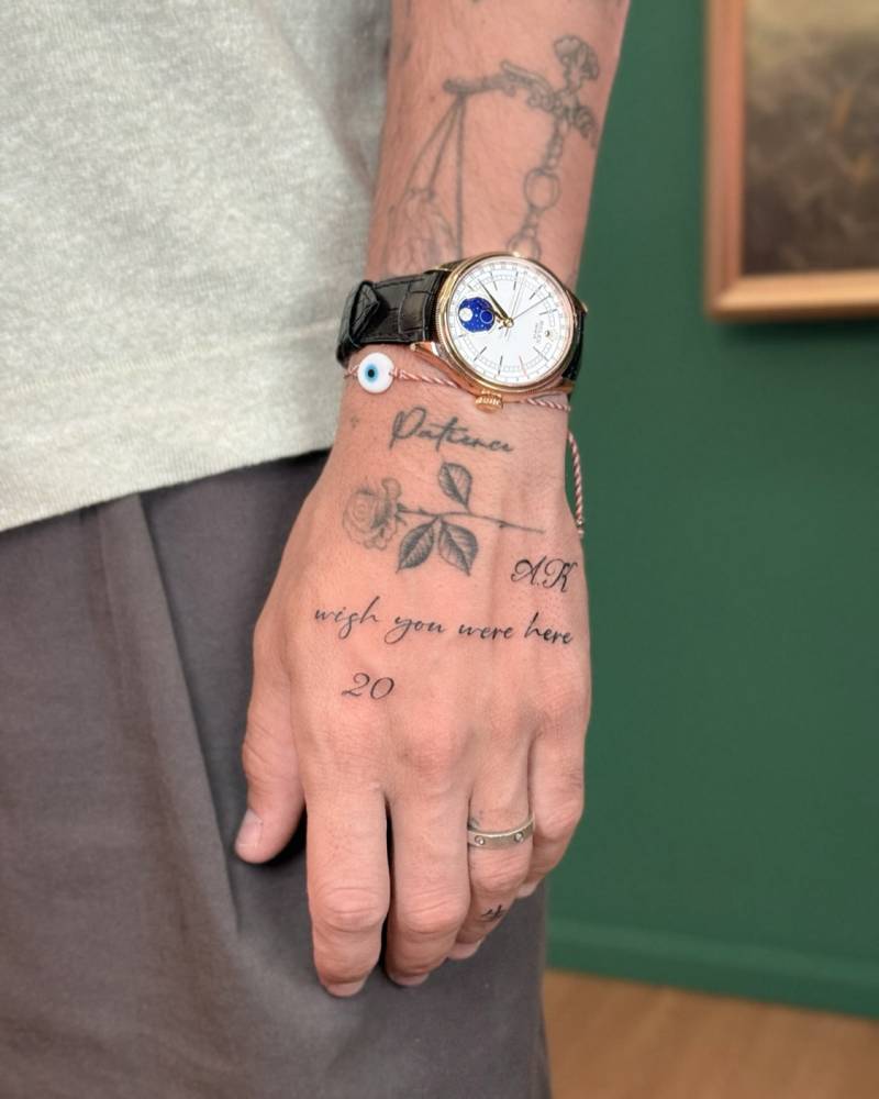 "Wish you were here" and number "20" tattooed on the hand.