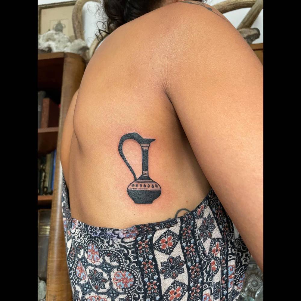 Blackwork style vase tattoo located on the back.