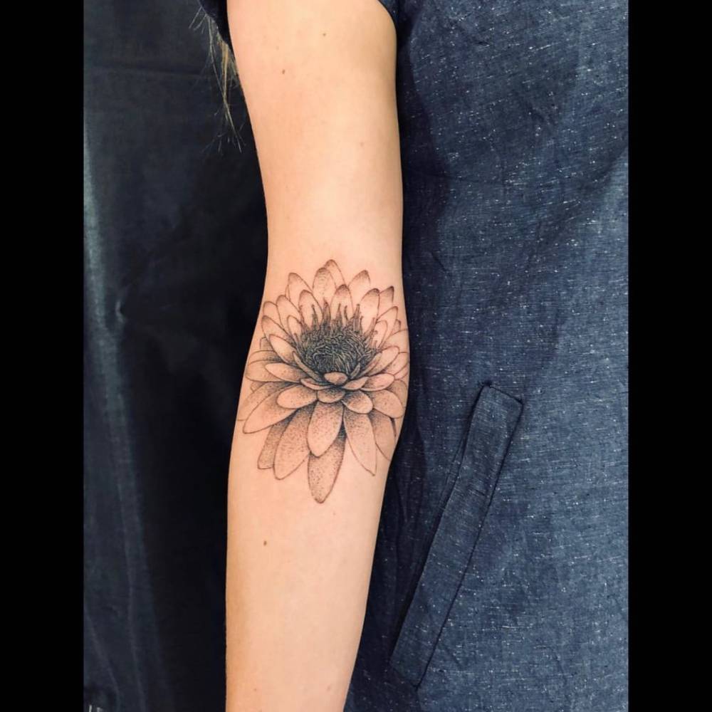 Chrysanthemum flower tattoo located on the inner forearm, blackwork style.