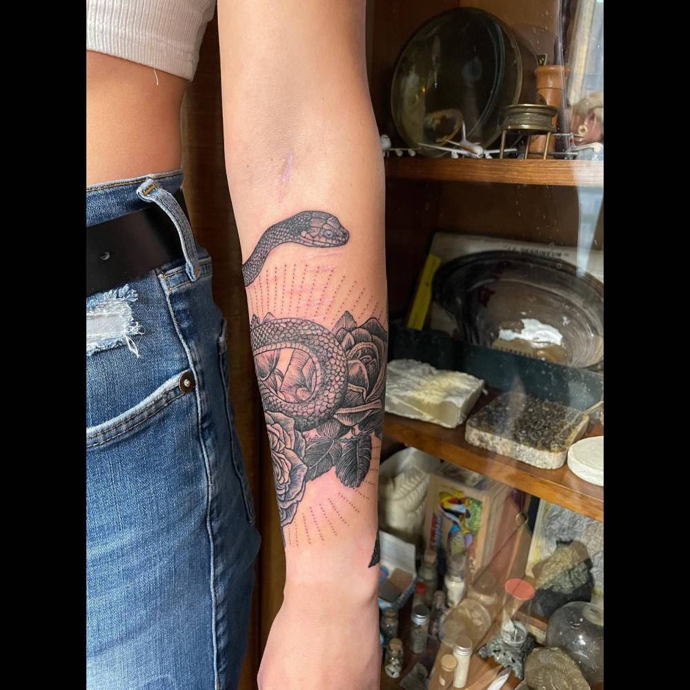 Illustrative style snake and rose tattoo done on the forearm.