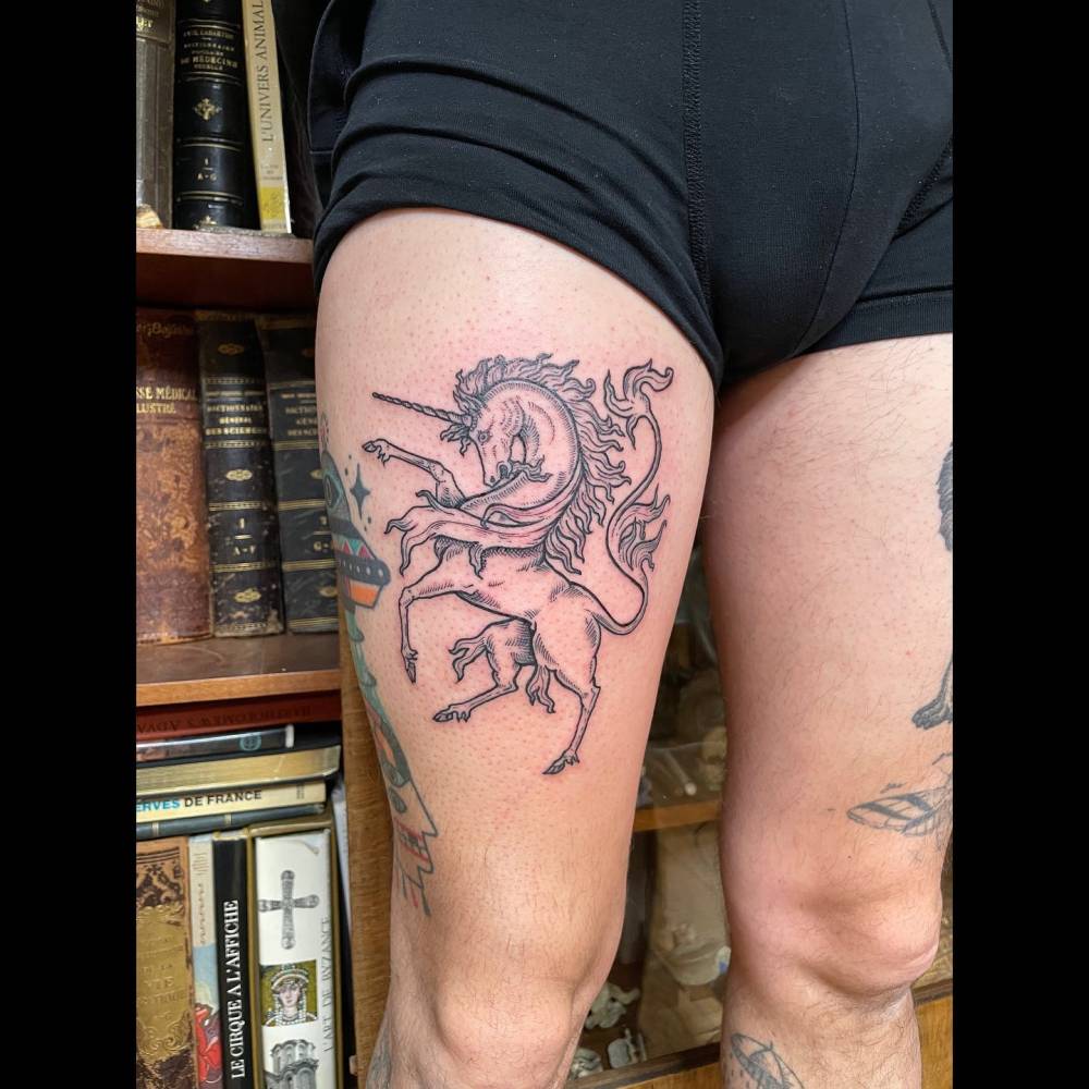 Unicorn tattoo in illustrative style located on the thigh.