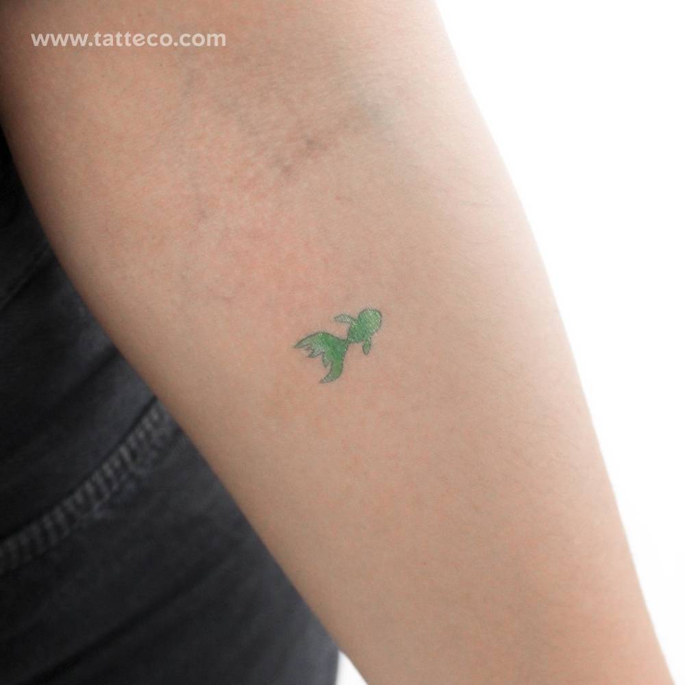 Tiny green fish temporary tattoo placed on the inner forearm.