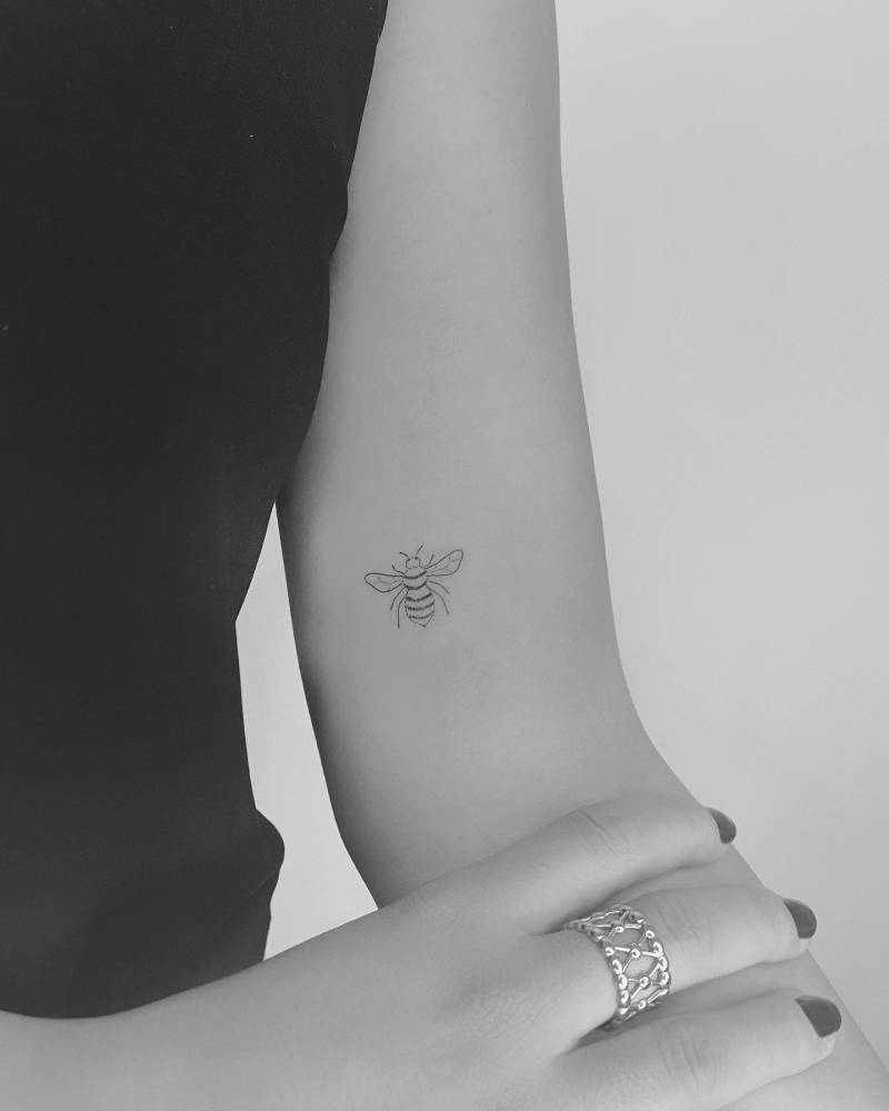 Little bee tattoo done on the inner arm, fine line style.