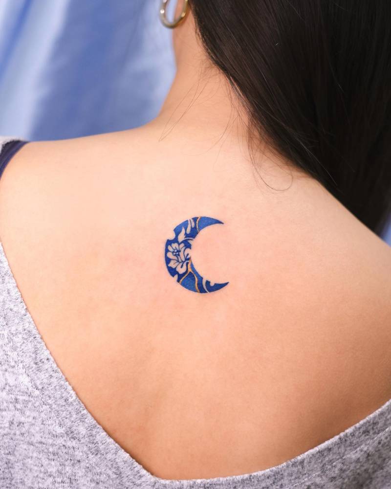 Kintsugi porcelain moon tattooed on the upper back.