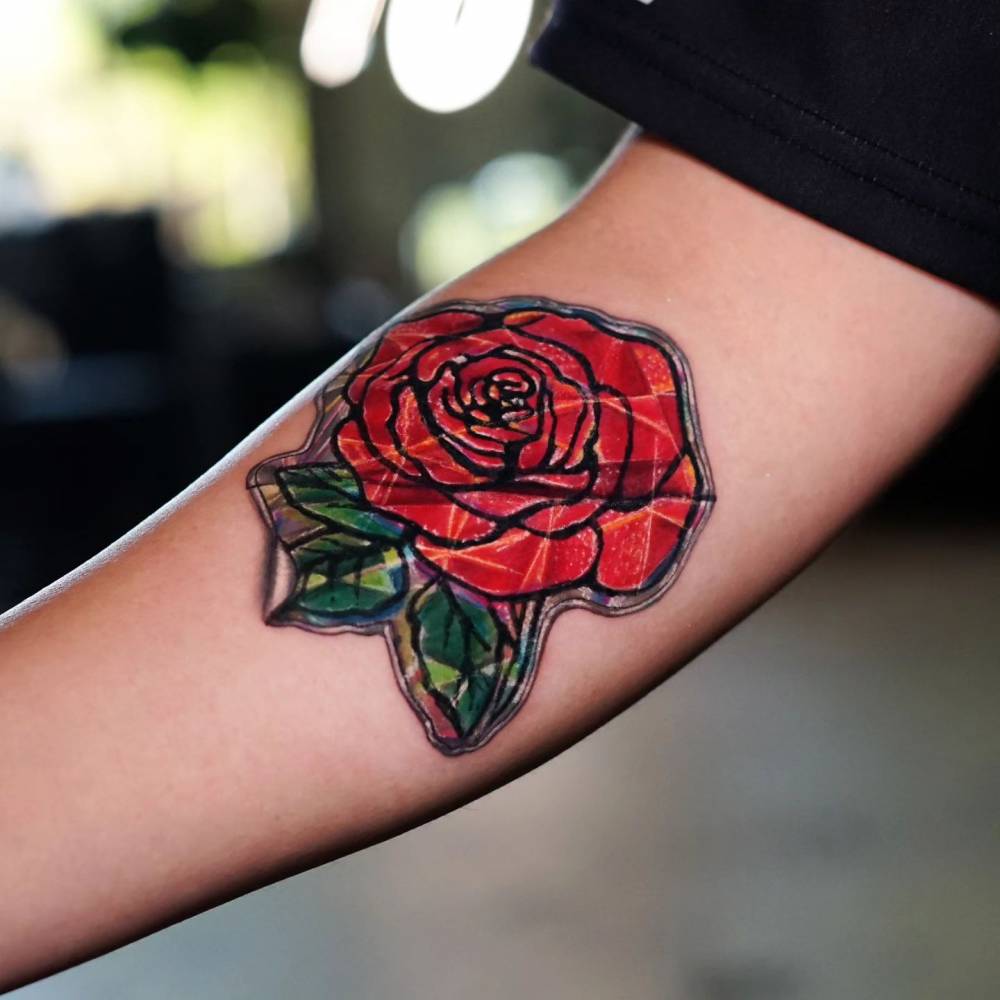 Red rose sticker tattoo located on the inner forearm.