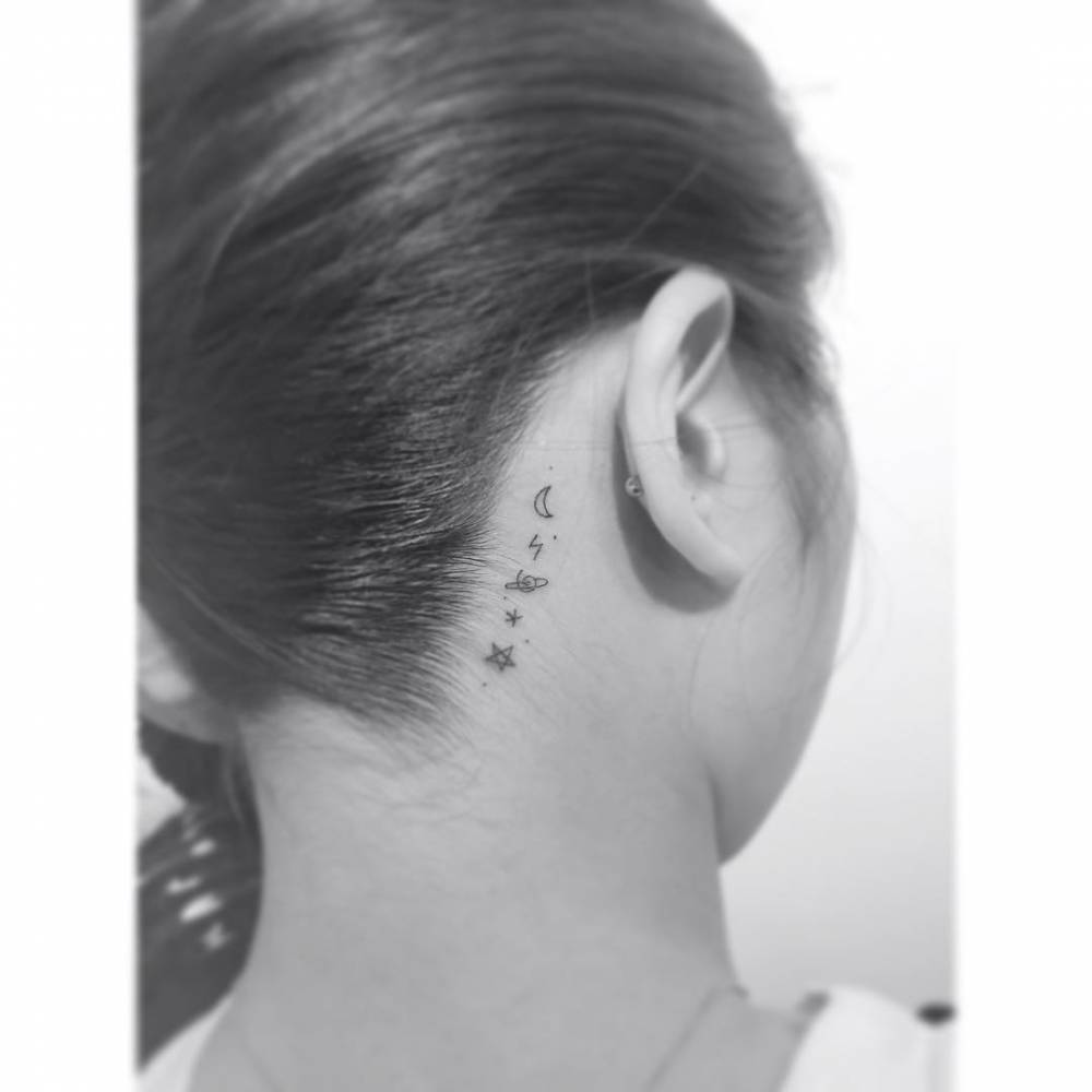 Galaxy tattoo in minimalistic style placed behind the ear.