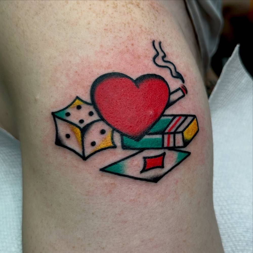 Heart, cigarette, dice and card tattoo located on the shoulder, traditional style.