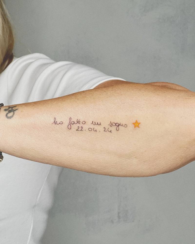 Handwritten Italian quote and date tattoo placed on the forearm.