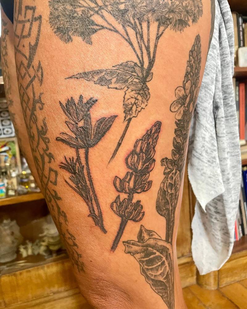 Blackwork style floral gap filler designs tattooed on the thigh.