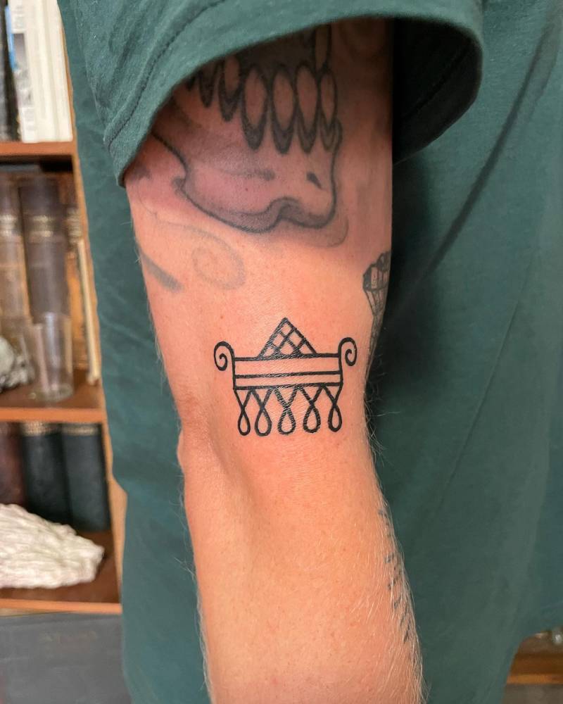 Ornamental design in blackwork style tattooed on the upper arm.