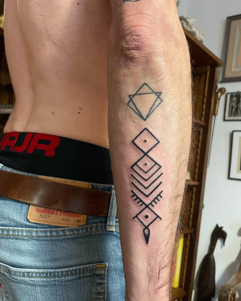 Geometric tattoo in blackwork style located on the forearm.