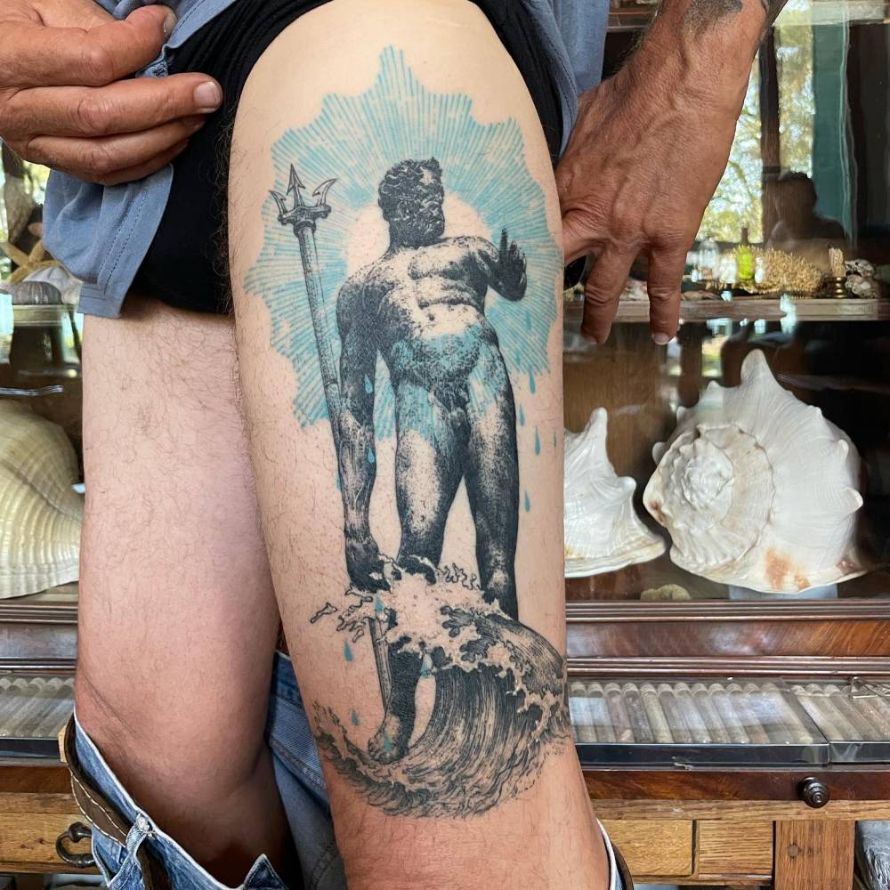Huge graphic style Neptune tattoo placed on the thigh.